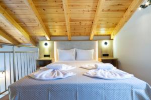 a bedroom with a bed with two towels on it at Sky View Suites Kefalonia in Vóvikes