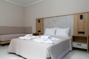 a bedroom with a white bed with two towels on it at Sky View Suites Kefalonia in Vóvikes