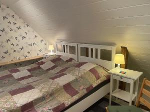 ein Schlafzimmer mit einem Bett mit einer Decke darauf in der Unterkunft Bienenhof Illers in Wieda