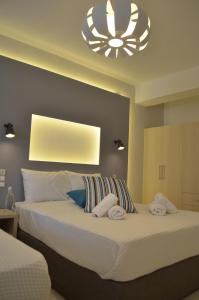 1 dormitorio con 2 camas y lámpara de araña en Ammos Apartments en Glífa