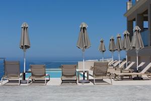 a group of chairs and umbrellas on a patio at Sky View Suites Kefalonia in Vóvikes
