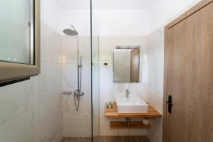 a bathroom with a sink and a shower at Sky View Suites Kefalonia in Vóvikes