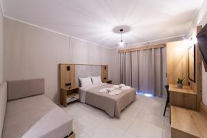 a hotel room with a bed and a window at Sky View Suites Kefalonia in Vóvikes