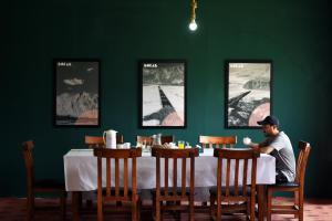 Ein Mann, der an einem Tisch in einem Restaurant sitzt. in der Unterkunft LOKAL Rooms x Skardu (Mountain View) in Skardu