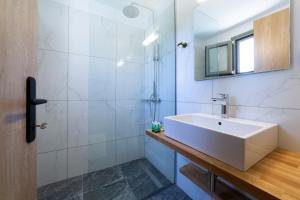 a bathroom with a white sink and a shower at Sky View Suites Kefalonia in Vóvikes