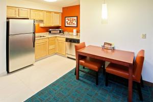 a kitchen with a table and a refrigerator at Residence Inn Indianapolis Fishers in Fishers