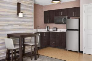 a kitchen with a small table and a refrigerator at Residence Inn Indianapolis Northwest in Indianapolis