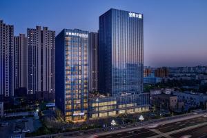 un groupe de grands bâtiments dans une ville la nuit dans l'établissement Fairfield by Marriott Zibo, à Zibo