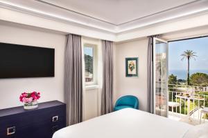a hotel room with a bed and a balcony at Pazziella Garden & Suites in Capri