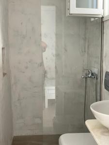 een badkamer met een douche, een toilet en een wastafel bij Zinas pension in Ios Chora
