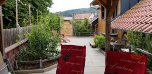 een tuin met tomatenplanten en rode kussens op een balkon bij Alte Scheune in Mossautal