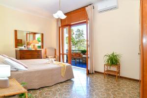 - une chambre avec un lit et une porte donnant sur une terrasse dans l'établissement Villa Li Campi, à Massa Lubrense