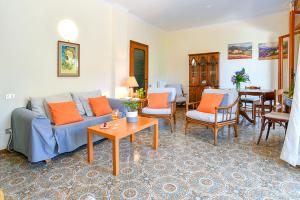 Villa Li Campi في ماسا لوبرينس: غرفة معيشة مع أريكة زرقاء ووسائد برتقالية
