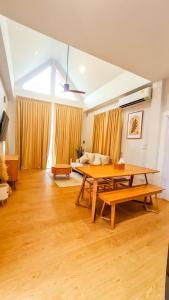 een grote woonkamer met een tafel en een bank bij child shill pool villa in Ban Wang Bot