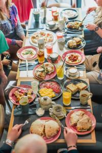 a long table filled with plates of food and people eating at Apartamenty BalticON Nadmorskie Tarasy in Kołobrzeg