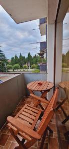 Duas mesas e cadeiras de madeira numa varanda em relax em Samtredia