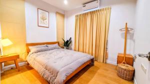 a bedroom with a bed and a table and a window at child shill pool villa in Ban Wang Bot +8 photos