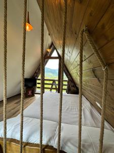 Bett in einem Zimmer mit Holzdecke in der Unterkunft Cabana A in Borşa
