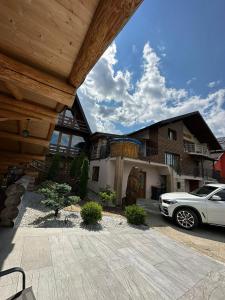 a white car parked in front of a house at Cabana A in Borşa