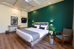 um quarto com uma cama grande e uma parede verde em LOKAL Rooms x Skardu (Mountain View) em Skardu