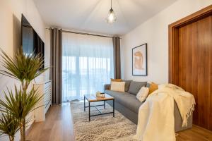 a living room with a couch and a tv at Lakeview Modern Condo-Tennis, Parking, Balcony in Cluj-Napoca