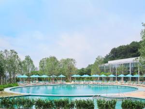 einen Pool mit Stühlen und Sonnenschirmen in einem Resort in der Unterkunft Ananti at Busan Village in Busan