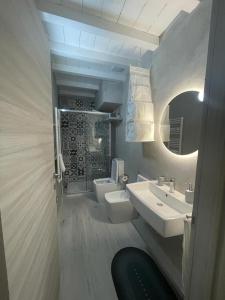 y baño con 2 lavabos, aseo y espejo. en Borgata di Levante, en Siracusa