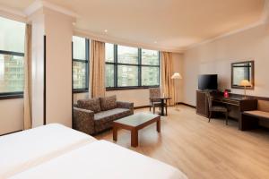 una camera d'albergo con letto, sedia e scrivania di Exe Oviedo Centro a Oviedo