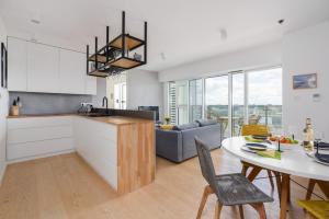 a kitchen and a living room with a table at 14th Floor City Center View Apartment Towarowa 37 by Renters in Poznań
