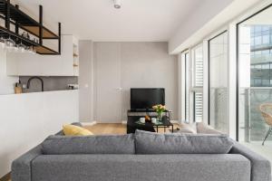 a living room with a couch and a tv at 14th Floor City Center View Apartment Towarowa 37 by Renters in Poznań