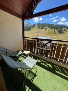 a balcony with chairs and a view of the mountains at Studio Dama neuf 4 p avec terrasse vue imprenable in Montgenèvre