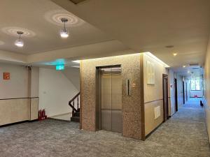 an empty hallway with a elevator in a building at Home Full Hotel in Jincheng