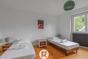 a bedroom with two beds and a window at R'Apparts T4 Urban Loft in Noyarey