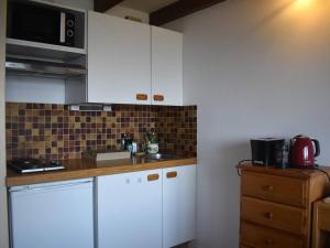 a kitchen with white cabinets and a microwave at Studio Font-Romeu-Odeillo-Via, 2 pièces, 6 personnes - FR-1-580-93 in Font-Romeu-Odeillo-Via