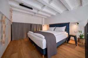 1 dormitorio con 1 cama grande en una habitación en Queen Barbora Central Lofts, en Kaunas