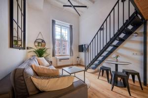 a living room with a couch and a table at Queen Barbora Central Lofts in Kaunas
