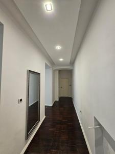 an empty hallway with white walls and a mirror at Azzuro apartment Self check in in Rijeka