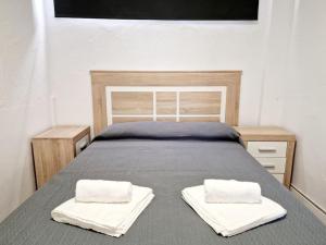 a bed with two white towels on top of it at Ground floor Apt in La Cala in Mijas Costa