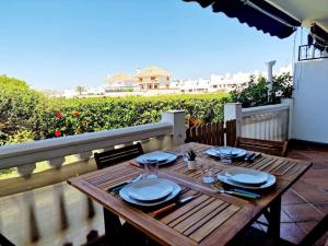 a wooden table with plates and napkins on a patio at Ground floor Apt in La Cala in Mijas Costa