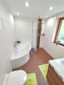 a bathroom with a tub and a sink and a toilet at Unterm Nussbaum 2 in Rassing +15 photos