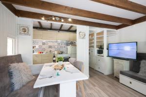 a kitchen and living room with a table and a tv at Résidence Grand Roc - Campanules 101 - Happy Rentals in Chamonix