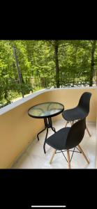 einen Tisch und zwei Stühle auf einem Balkon mit Fenster in der Unterkunft Apartment VR home hilly side in Zaghkadsor