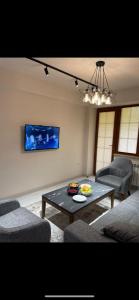 sala de estar con mesa, sillas y TV en Apartment VR home hilly side en Tsaghkadzor