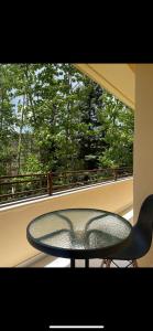 a glass table and a chair on a balcony at Apartment VR home hilly side in Tsaghkadzor