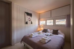 a bedroom with a bed with towels on it at Résidence Grand Roc - Campanules 101 - Happy Rentals in Chamonix