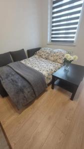 a bedroom with a bed and a table with flowers on it at Apartament "Cztery Pory Roku" in Świdnik