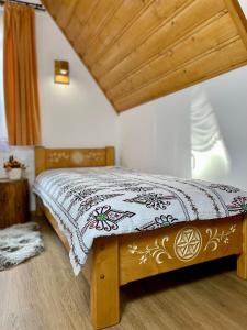a bedroom with a bed with a blanket on it at Leszczyniański Domek in Biały Dunajec