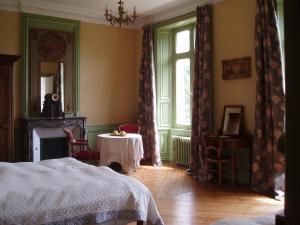 a room with a bed and a table and a window at Chateau des poteries in Fresville
