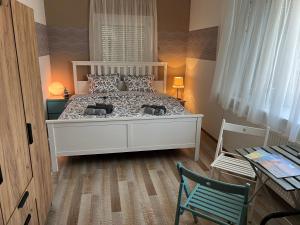 ケストヘイにあるSzarkafészekのベッドルーム(白いベッド1台、緑の椅子付)