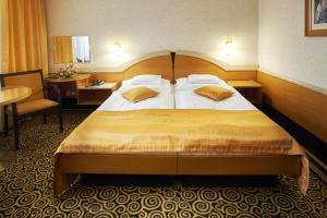 pokój hotelowy z dużym łóżkiem i stołem w obiekcie Hotel Eroplán w mieście Rožnov pod Radhoštěm